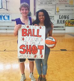 two people standing on a basketball court holding a sign that says ball i picked up and shot