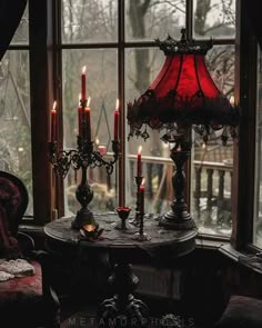 a red lamp sitting on top of a table next to a window