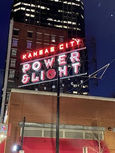 the kansas city power and light sign is lit up in front of a tall building