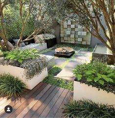 an outdoor area with plants and trees on the ground, surrounded by wooden decking