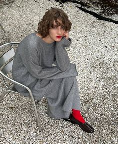 a woman sitting on top of a metal chair