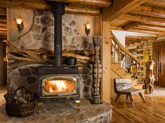 a wood burning stove sitting inside of a living room next to a wooden floor and stairs