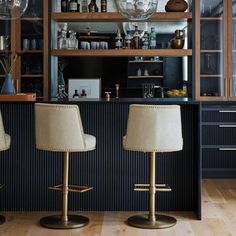 two bar stools in front of an open bookcase