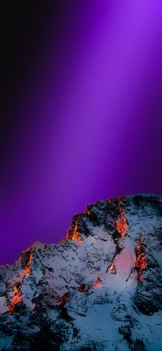 the mountain is covered in snow and red hot lava as it rises into the night sky