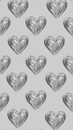 many silver hearts are arranged in the shape of a heart on a gray background photo