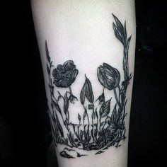 a black and white photo of some flowers on the arm, with grass growing out of it