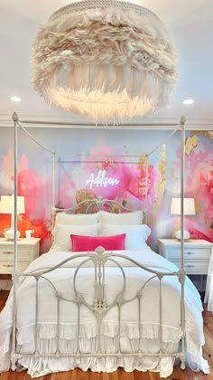 a white bed sitting in a bedroom next to a pink and gold wallpaper covered with feathers