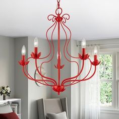 a red chandelier hanging from the ceiling in a room with white walls and windows