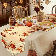 the table is set for thanksgiving dinner with fall decorations