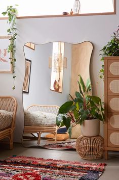 a living room filled with lots of plants next to a mirror and dresser covered in potted plants