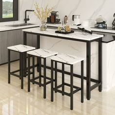 a modern kitchen with marble counter tops and black metal stools, along with an island in the middle