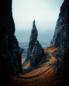 some very tall rocks on the side of a hill