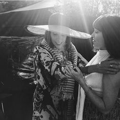 two women standing next to each other wearing hats