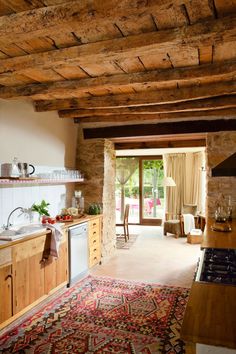 a kitchen area with a rug, sink and stove top oven in the middle of it