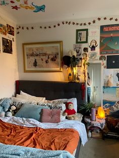 a bed room with a neatly made bed and many pictures on the wall above it