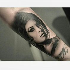 a woman's arm with a black and white photo on it, in the middle of her forearm