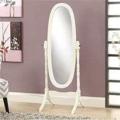 a large white mirror sitting on top of a wooden floor next to a purple wall