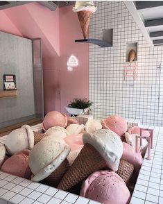 an ice cream parlor with pink and white walls, large scoops of ice cream on the counter