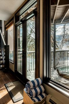 the sun shines through the open windows in this home's living room, which has been decorated with blue and white striped pillows