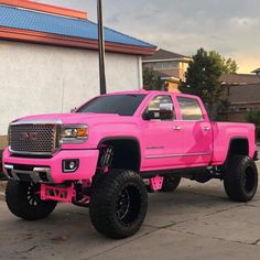 the pink truck is parked on the side of the road