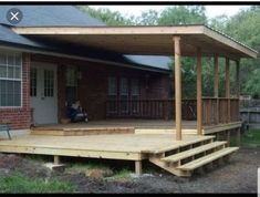 a wooden deck with steps leading up to the front door and covered patio area next to it