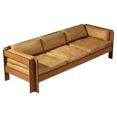 a wooden couch sitting on top of a white floor