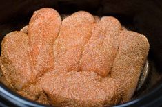 some kind of bread in a crock pot with sugar sprinkled on top