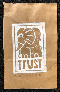 a brown paper bag with an elephant sticker on it's side that says trust