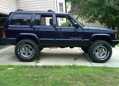 a blue jeep parked in front of a house