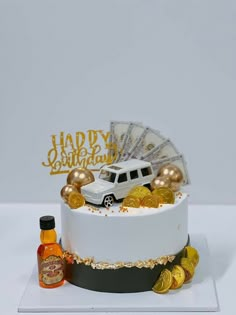 a birthday cake decorated with gold coins and a white car