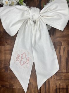 the monogrammed bow tie is tied to a wooden door with flowers on it