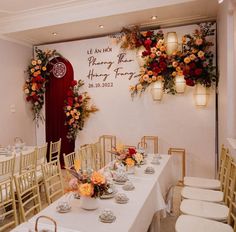 a dining room with tables and chairs set up for a formal function, decorated with flowers