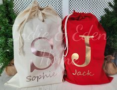 two bags with the letters s and j on them sitting next to some christmas trees