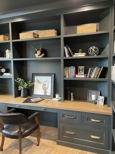 a home office with built - in bookcases and leather chair