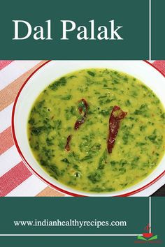 a bowl filled with green soup on top of a red and white table cloth