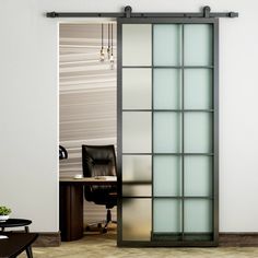 an open glass sliding door in the middle of a room with a desk and chair