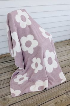 a purple and white flowered blanket sitting on top of a wooden floor