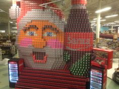 a large display made out of soda cans in a store with the face of a lion on it