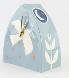 a clock that is on the side of a blue building with stars and moon designs