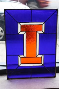 a blue and orange stained glass block with the letter i in it's center