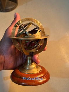 a person holding a small gold and black clock