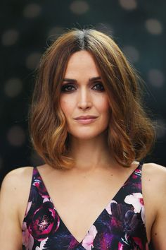 a woman with shoulder length hair wearing a floral dress