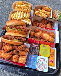 chicken sandwiches and waffles are sitting on a tray next to other food items