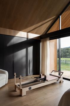 a bed sitting on top of a wooden floor next to a window