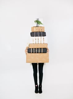 a woman is holding two stacks of luggage