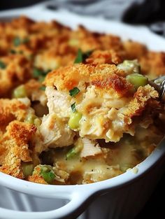 a casserole dish with chicken and vegetables in it is being eaten by a fork