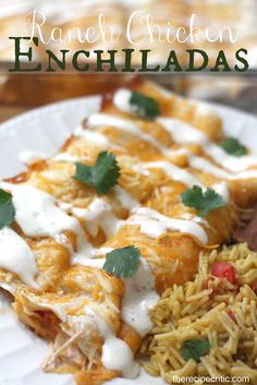 an enchiladas dish on a white plate topped with sour cream and cilantro