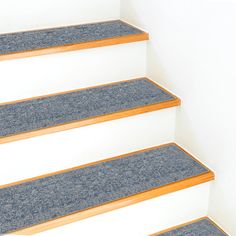 blue carpeted steps leading up to the top of a set of stairs with wooden handrails