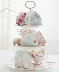 three tiered tea cups and saucers are stacked on top of each other with pink flowers