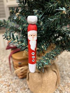 a wooden santa clause ornament hanging from a christmas tree